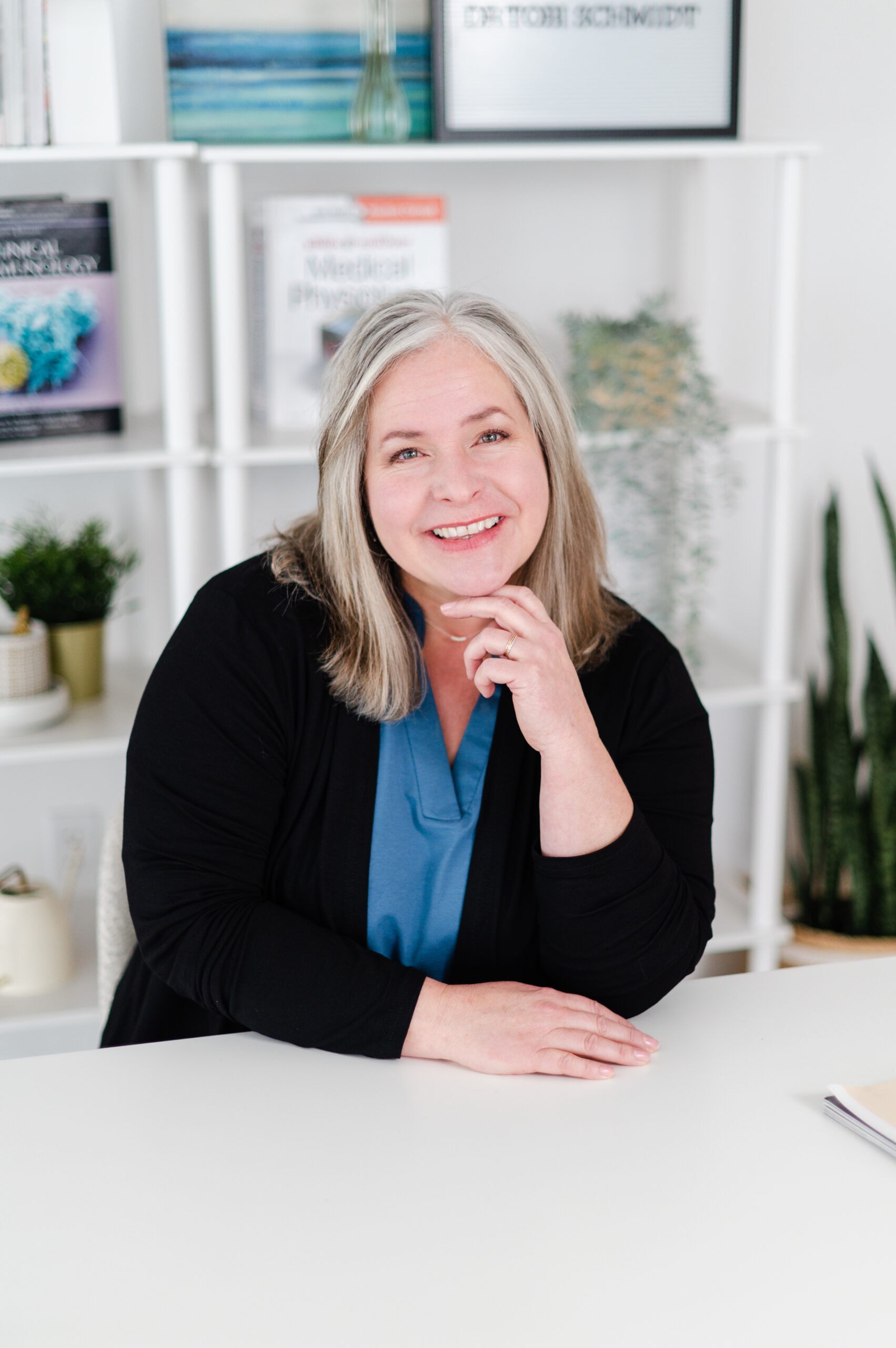 Dr. Tobi Schmidt sitting at desk smiling.